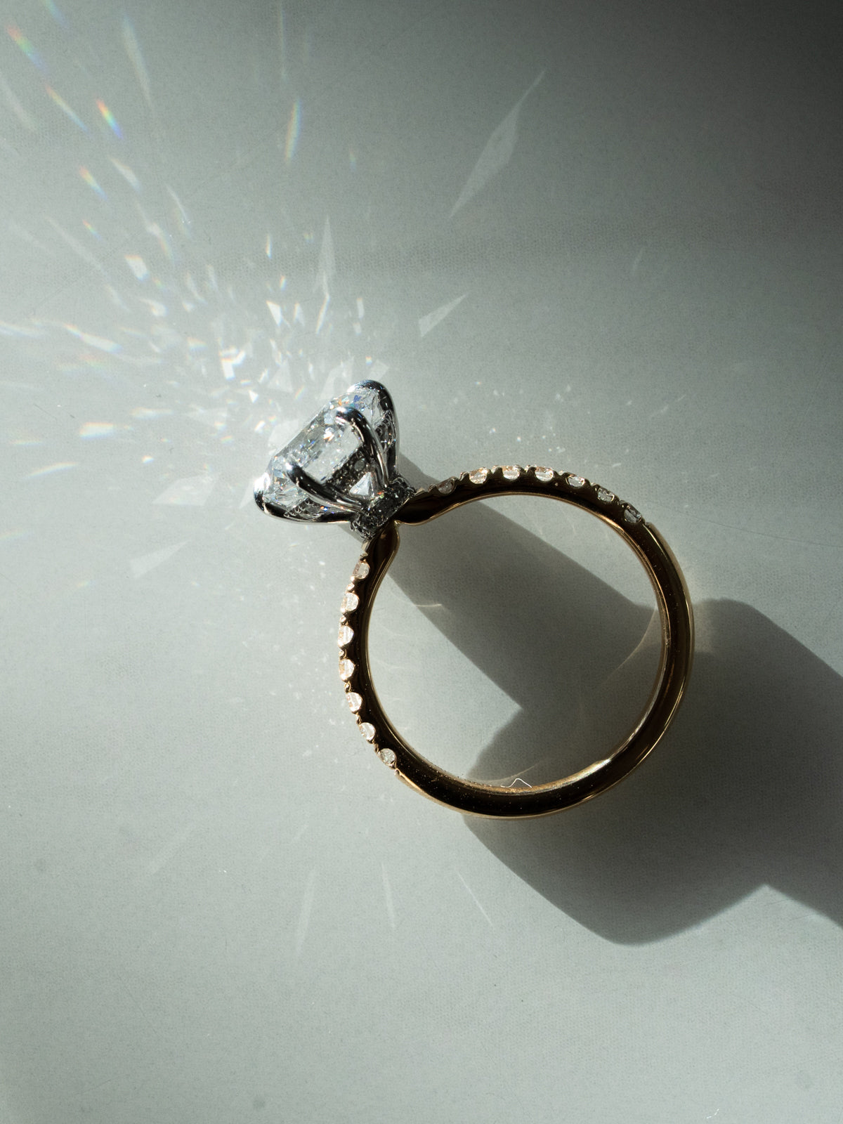 Round diamond engagement ring with light reflections showing brilliant cut sparkle and mixed metal setting