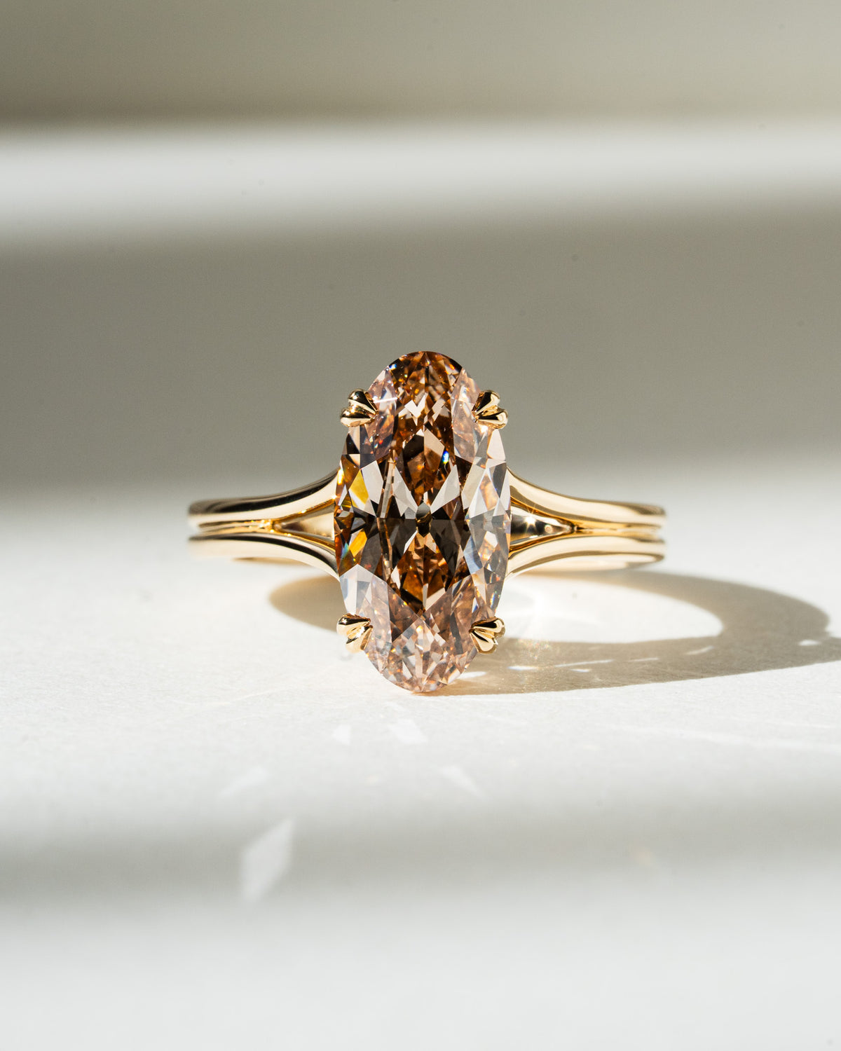 Gold ring with a large brown diamond on a light background