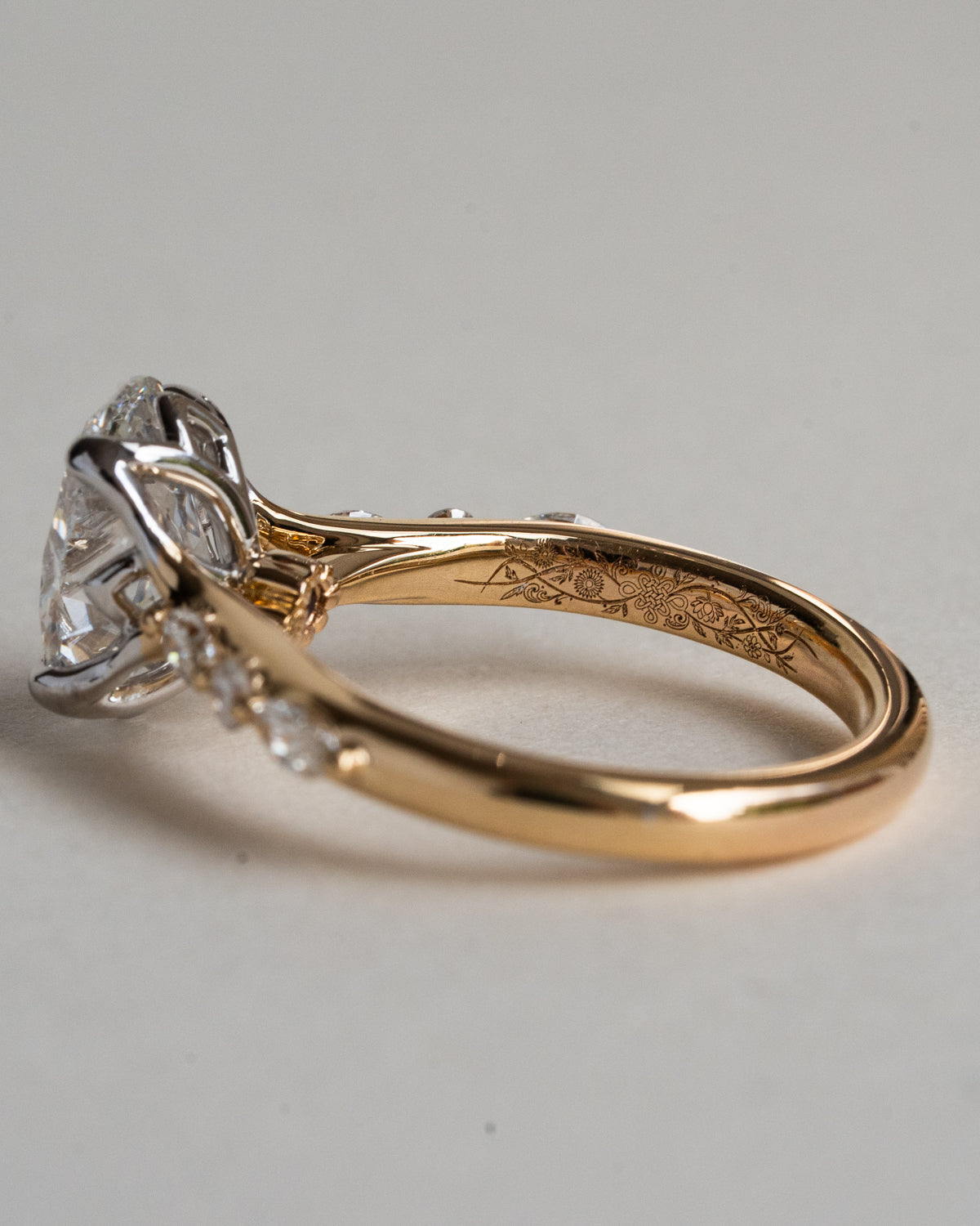 Inner band engraving of Chinese knot and daisy on oval diamond engagement ring in 18ct yellow gold. Chinese culture personalisation engraving. Hidden details.