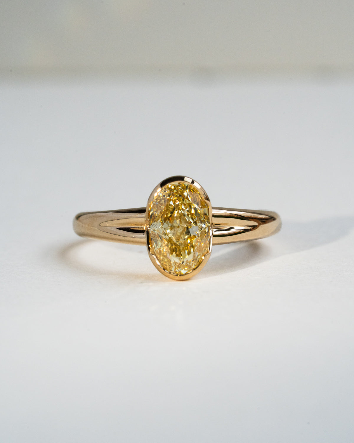 Oval yellow diamond with half bezel