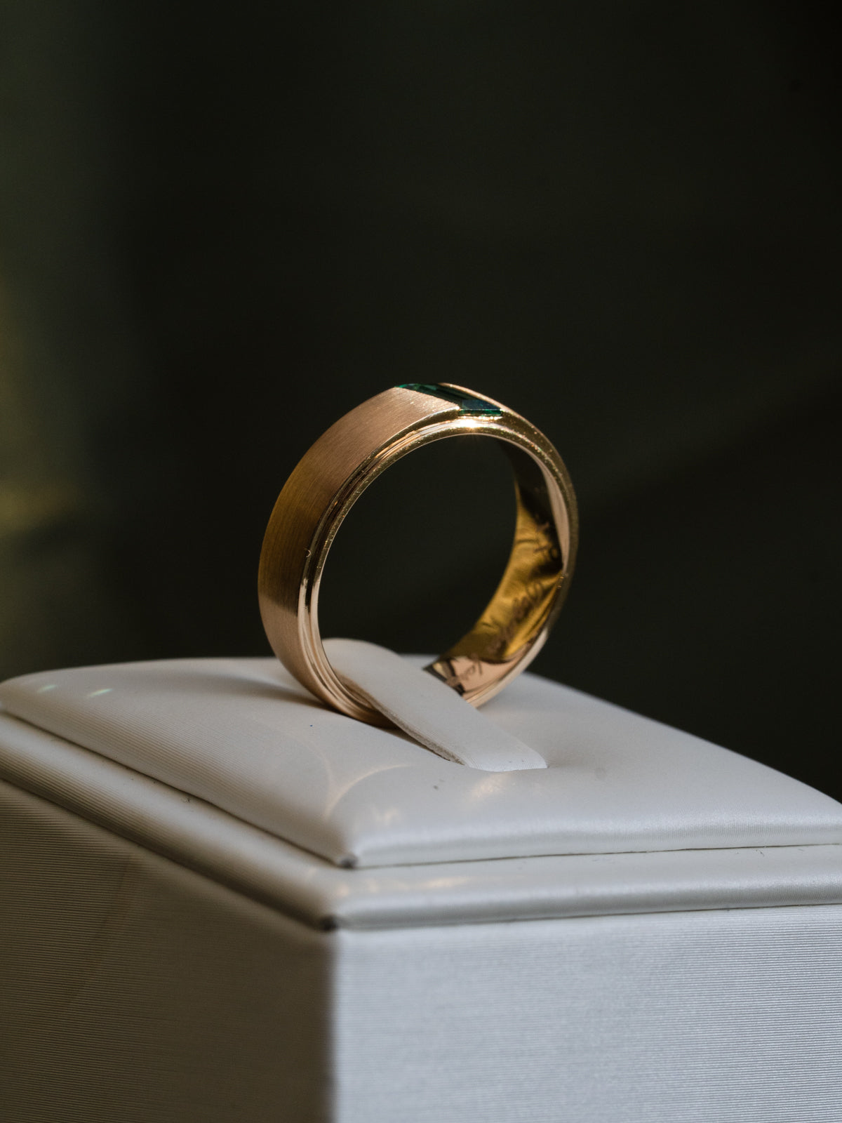 Contemporary men’s wedding band with geometric emerald and matte gold texture